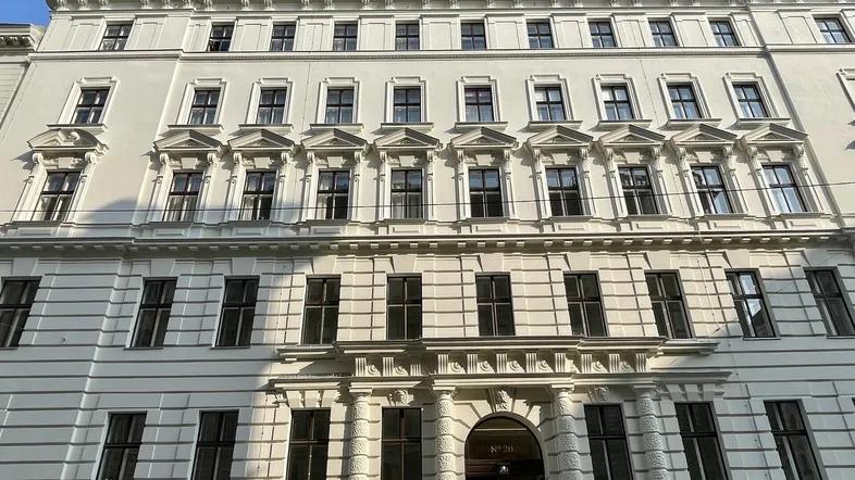 Die Fassade des historischen Gebäudes präsentiert sich mit vielen Fenstern und klassischer Architektur.
