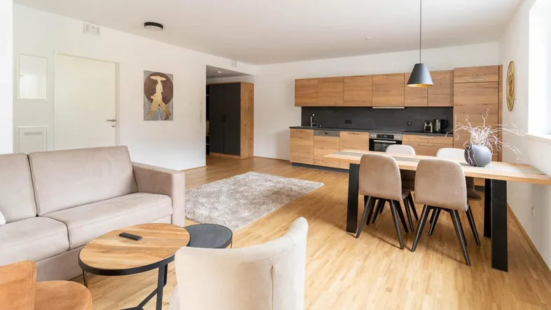 Helles, offenes Wohn-Esszimmer mit integrierter Holzküche und modernem Design.