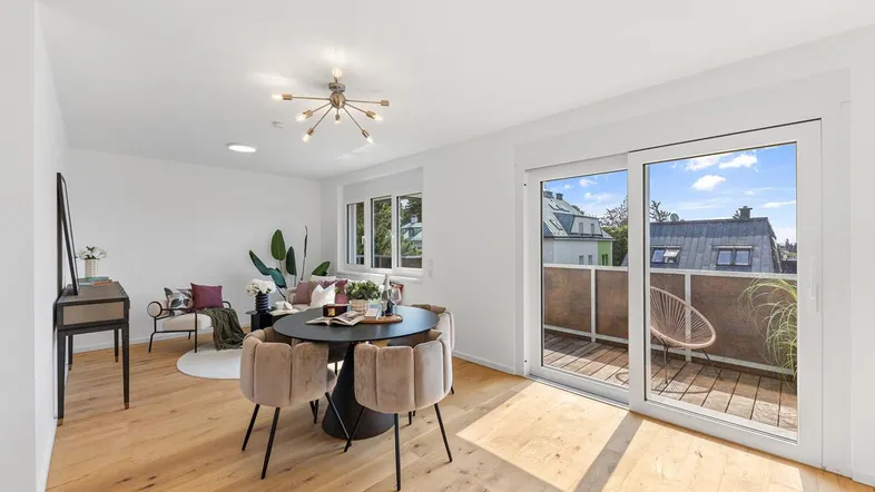 Heller Wohn- und Essbereich mit Holzboden, modernen Möbeln und Zugang zum Balkon.
