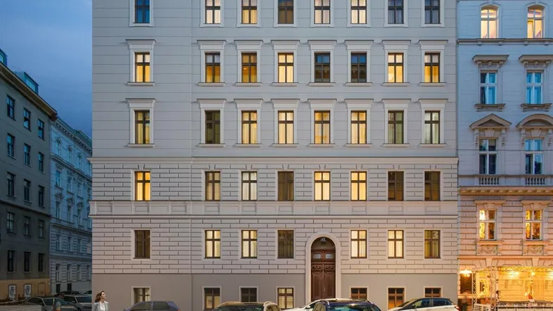Elegante Fassade eines Stadthauses mit beleuchteten Fenstern und klassischer Architektur am Abend.
