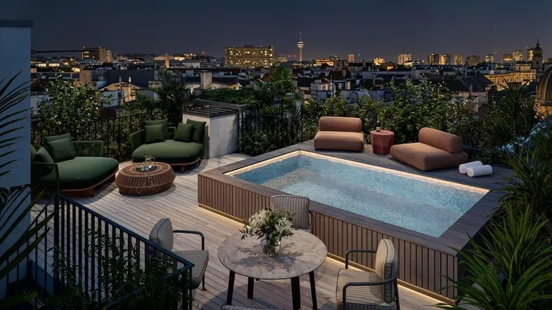 Luxuriöse Dachterrasse mit privatem Pool, bequemen Sitzgelegenheiten und beeindruckendem Stadtblick bei Nacht.