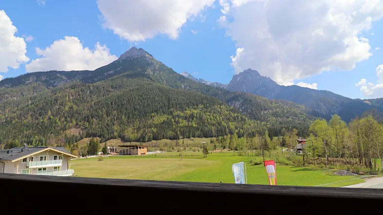 Panoramablick vom Balkon auf die majestätischen Berge und die grüne Landschaft.