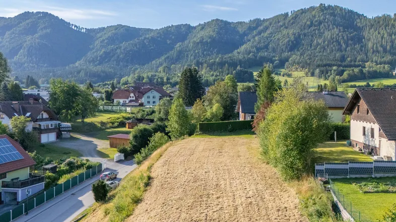 Großes Baugrundstück in ländlicher Umgebung mit Blick auf die umliegenden Berge und Wälder.