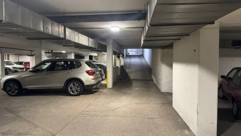 Tiefgarage mit mehreren Stellplätzen und einer Zufahrtsrampe für Fahrzeuge.