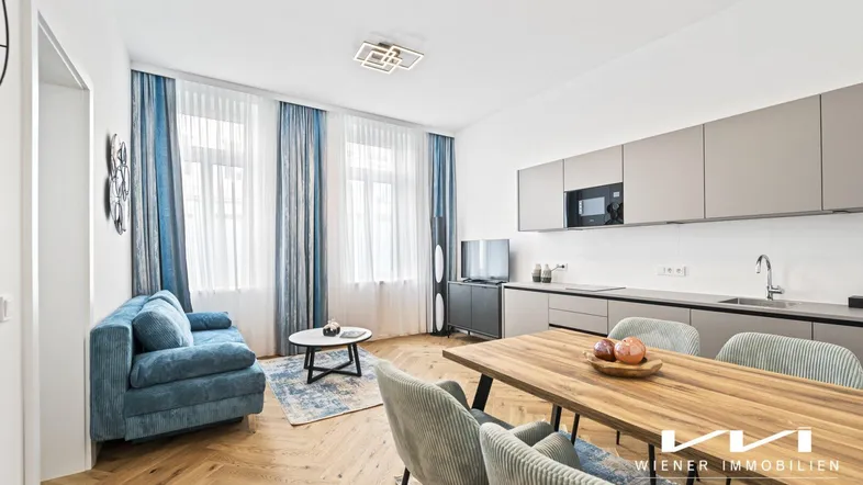 Helles, offenes Wohnzimmer mit integrierter Küche, Essbereich und modernem Fischgrätparkett.
