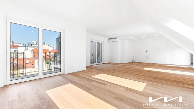 Helles, geräumiges Wohnzimmer mit Holzboden, großen Fenstern und Zugang zu einem Balkon.