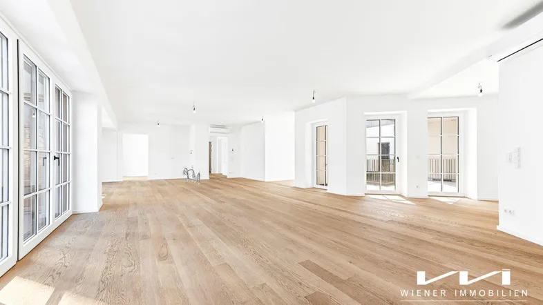 Helles, offenes Wohnzimmer mit neuem Eichenparkettboden und großen Fenstern, bereit für die Einrichtung.