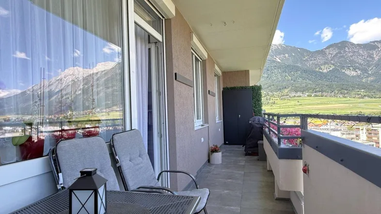 Möblierter Balkon mit Bergblick und Sitzgelegenheiten, ideal zum Entspannen im Freien.