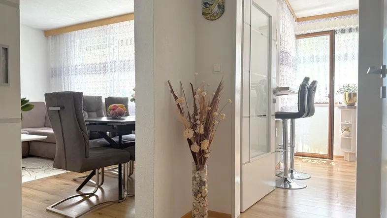 Heller Flur mit Holzboden, der zum Essbereich und zur Küche führt.