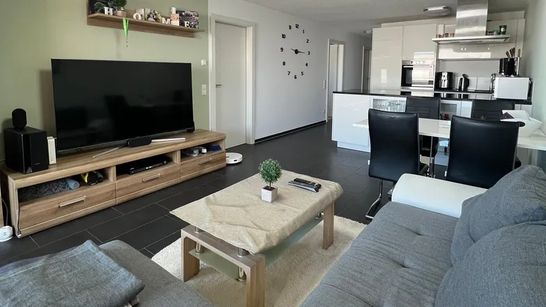 Heller offener Wohn- und Essbereich mit moderner Küche und Zugang zur Terrasse.