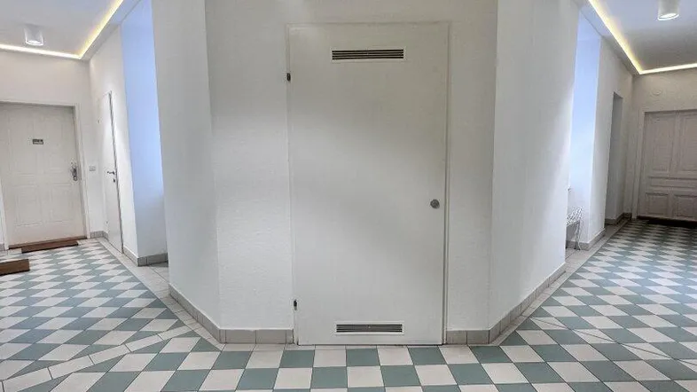 Heller Eingangsbereich mit modernem Fliesenboden und indirekter Deckenbeleuchtung.