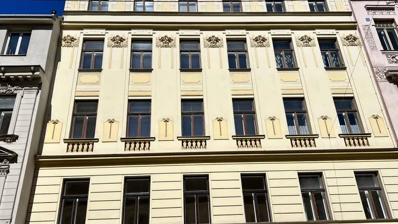 Historisches Gebäude mit klassischer Fassade und verzierten Balkongeländern in der Stadt.
