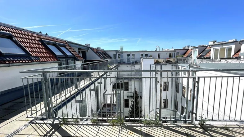 Geräumige Dachterrasse mit Blick auf den Innenhof und die umliegenden Dächer.