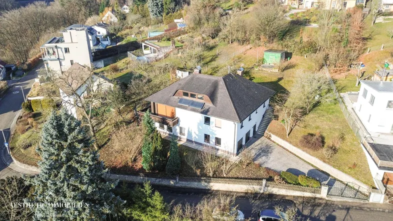 Luftaufnahme eines Einfamilienhauses mit Satteldach und umliegender Wohnbebauung.