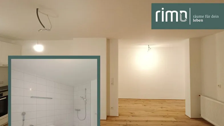 Heller Raum mit Holzboden und einem Badezimmerausschnitt, der eine Badewanne und Dusche zeigt.
