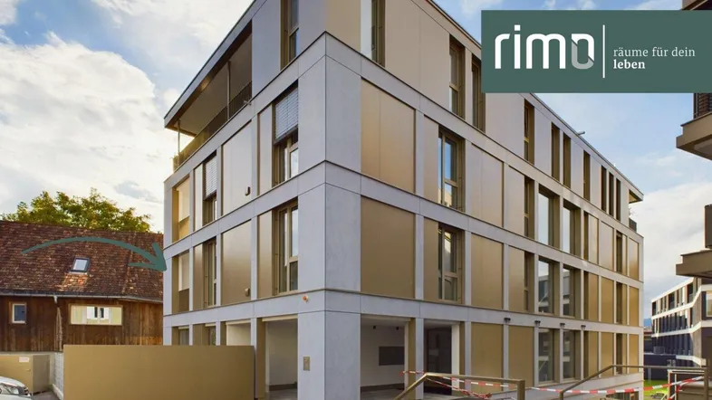 Modernes Mehrfamilienhaus mit zeitgenössischer Architektur und großen Fenstern in einer städtischen Umgebung.