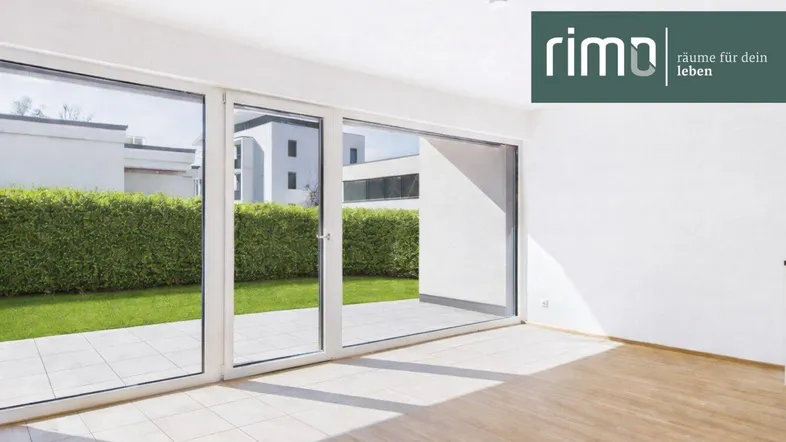 Helles Wohnzimmer mit großen Fensterfronten, die Zugang zu einer Terrasse und einem gepflegten Garten bieten.