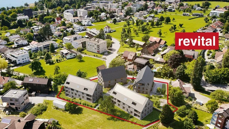 Luftaufnahme einer geplanten Wohnanlage am Seeufer mit grüner Umgebung und Neubauten.