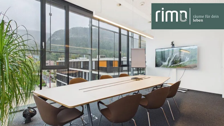 Moderner Konferenzraum mit großen Fenstern, die einen weiten Blick auf die Berge bieten.
