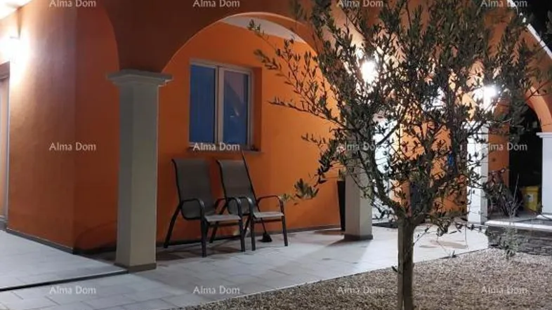 Außenansicht des Hauses bei Nacht mit beleuchteter Terrasse und Sitzgelegenheiten.