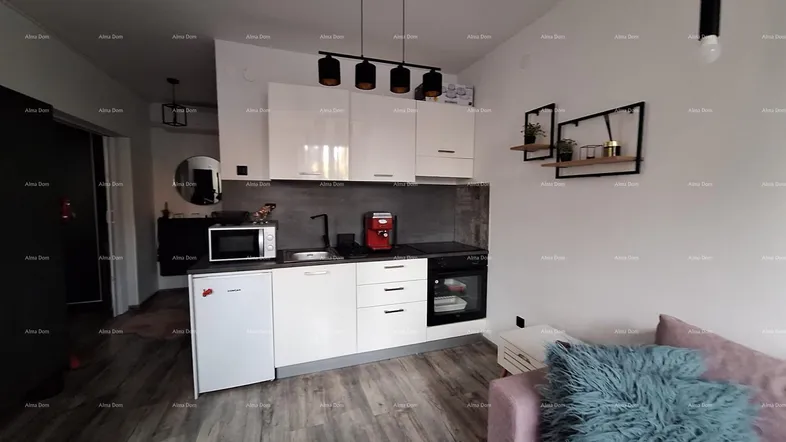 Moderne Küchenzeile in einem offenen Wohnbereich mit Holzboden und minimalistischer Einrichtung.