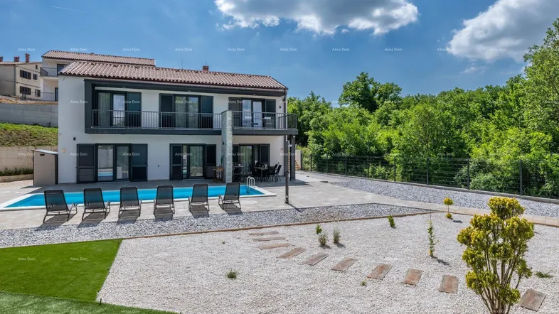 Modernes Haus mit Pool, Liegestühlen und gepflegtem Gartenbereich unter blauem Himmel.