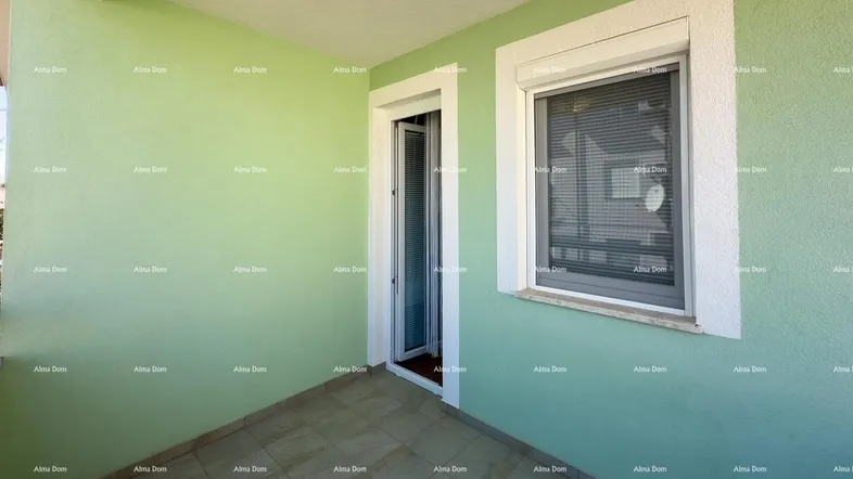 Heller Balkon mit hellgrünen Wänden, Fliesenboden und Fenster mit Rollladen.