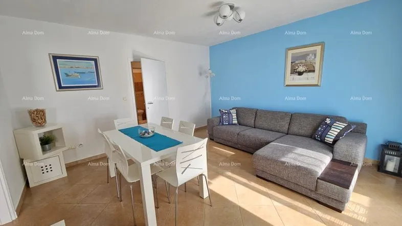 Heller Wohn-Essbereich mit modernem Sofa, weißem Esstisch und blauer Akzentwand.