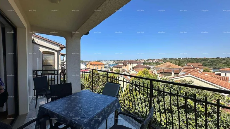 Möblierter Balkon mit schmiedeeisernem Geländer und weitem Blick über die Dächer und das Meer.
