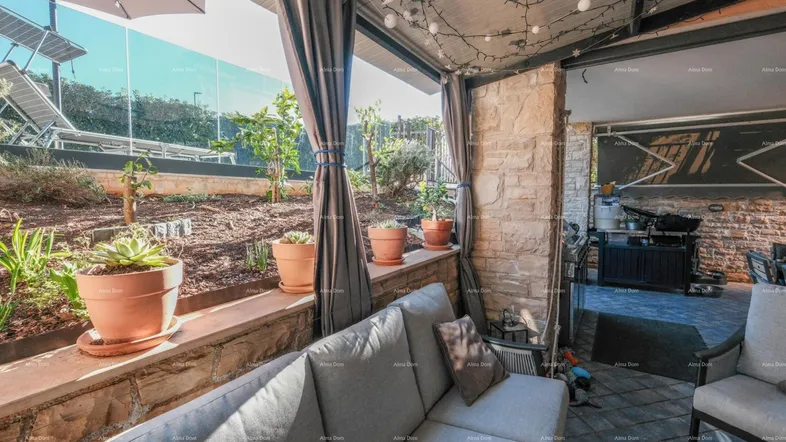 Überdachte Terrasse mit gemütlicher Sitzecke, Steinwänden und Blick auf den Garten.