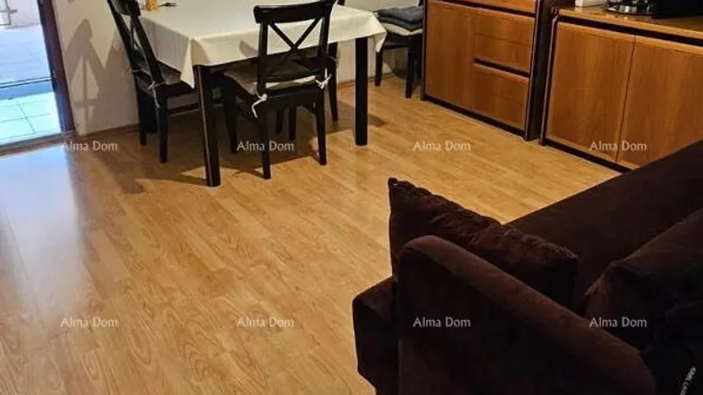 Helles Wohn- und Esszimmer mit Holzboden, Esstisch und bequemer Couch.