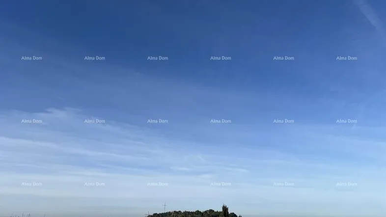 Weiter Blick über das Meer, den Hafen mit Booten und die Dächer der Stadt unter blauem Himmel.