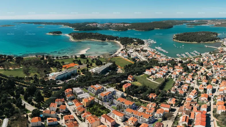 Panoramablick aus der Vogelperspektive auf eine Küstenstadt mit modernen Gebäuden und dem Meer.