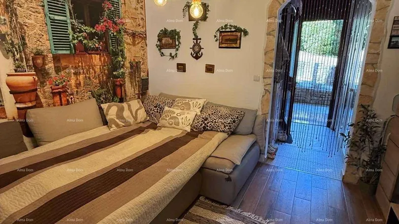 Gemütliches Wohnzimmer mit großem Sofa, rustikalem Seil-Kronleuchter und dekorativer Steinwand.