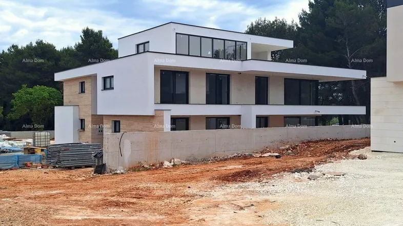 Moderne Villa im Bau mit klaren Linien und großen Fensterfronten in natürlicher Umgebung.