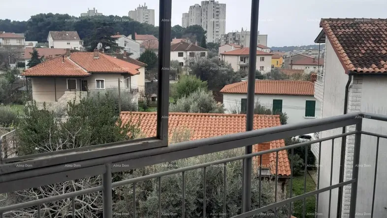 Geräumiger Balkon mit Metallgeländer und Blick auf die umliegende Wohngegend und Bäume.