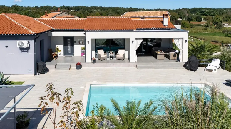 Luxuriöse Villa mit großem Pool, weitläufiger Terrasse und gemütlichen Outdoor-Sitzbereichen unter freiem Himmel.