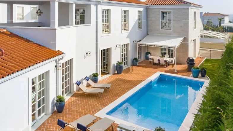 Luxuriöse Villa mit großem Pool, weitläufiger Terrasse und Essbereich im Freien unter einer Markise.