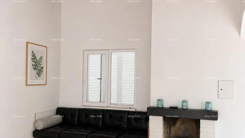 Gemütliches Wohnzimmer mit Holzbalkendecke, Kamin und integriertem Sofa, bietet eine warme Atmosphäre.