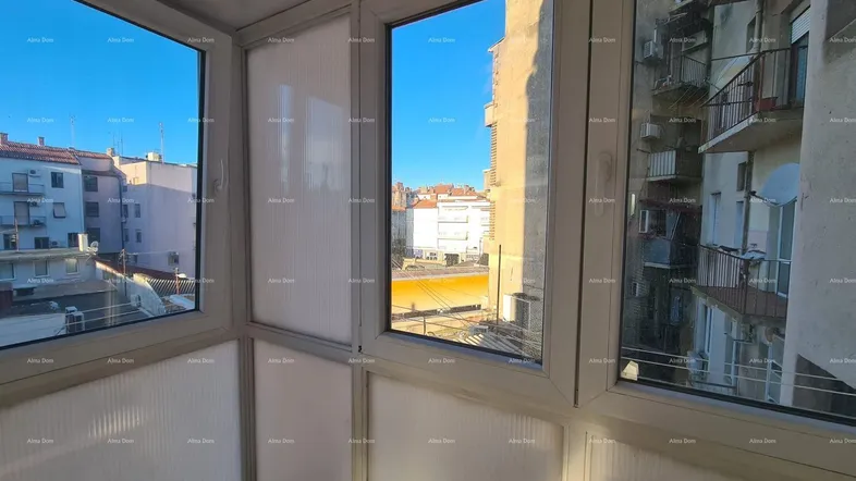 Verglaster Balkon oder Wintergarten mit Blick auf die umliegenden Gebäude und die Stadt.