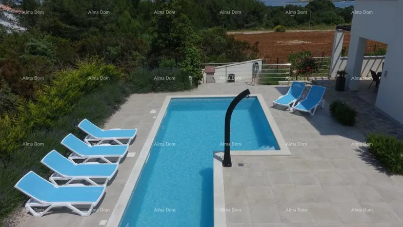 Großzügiger Außenbereich mit modernem Pool, Sonnenliegen und weitem Blick auf die umliegende Landschaft und das Meer.