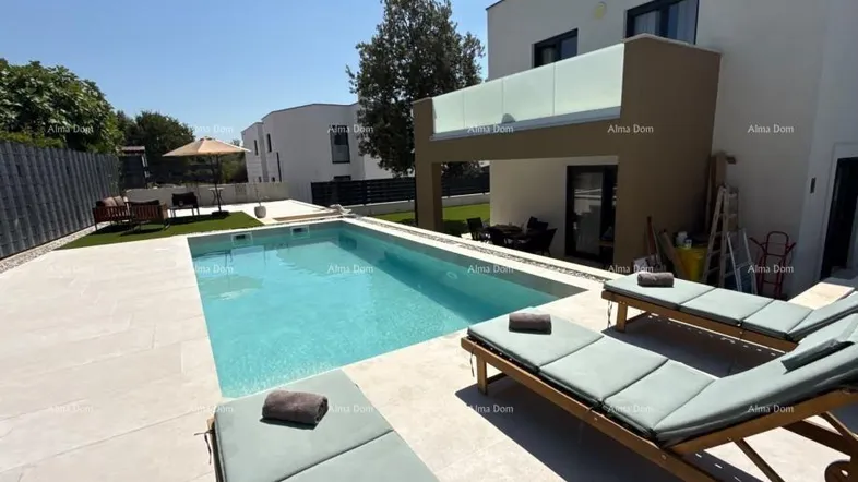 Moderner Außenbereich mit großem Swimmingpool, Sonnenliegen und gepflegtem Rasen, ideal zum Entspannen.