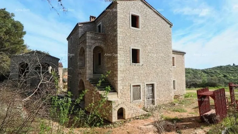 Steinhaus im Rohbauzustand mit traditioneller Architektur und umliegender Natur.