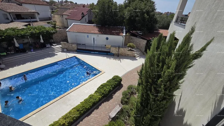 Luftaufnahme des Anwesens mit großem Swimmingpool und umliegenden Gebäuden unter blauem Himmel.