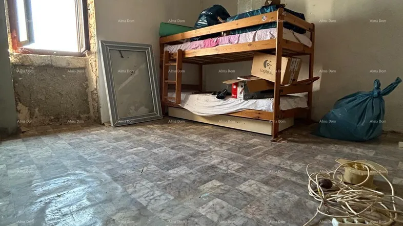 Schlafzimmer im Rohbau mit Etagenbett, freiliegenden Holzbalken und einem Fenster.