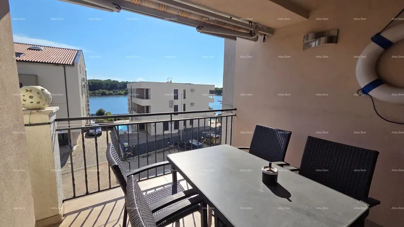Geräumiger Balkon mit Esstisch und Stühlen, bietet einen schönen Blick auf das Wasser und die umliegenden Gebäude.