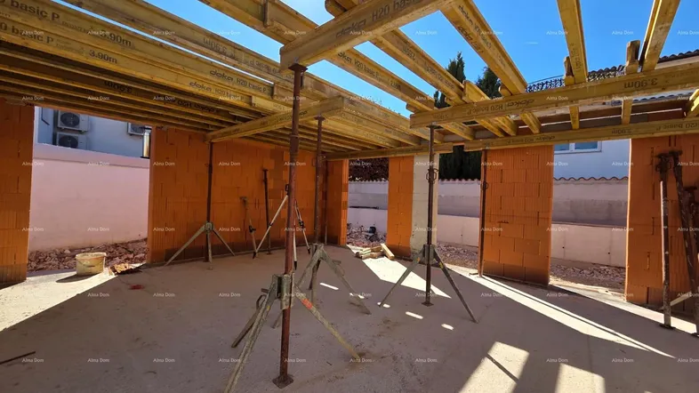 Baustelle eines im Bau befindlichen Hauses mit sichtbaren Ziegelwänden und Holzschalung.