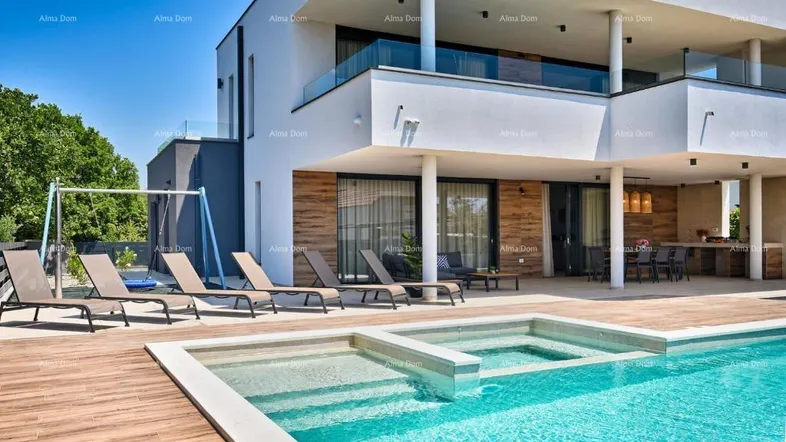 Moderne Villa mit großem Poolbereich, Sonnenliegen und Whirlpool, umgeben von Holzdeck.