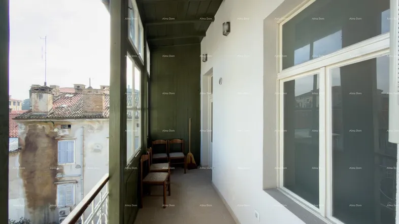 Langer, schmaler Balkon mit Blick auf die Dächer der Altstadt und einfacher Möblierung.