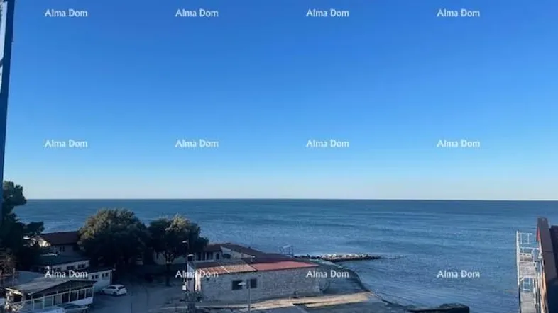 Panoramablick auf das Meer und die Küste mit einigen Gebäuden unter blauem Himmel.